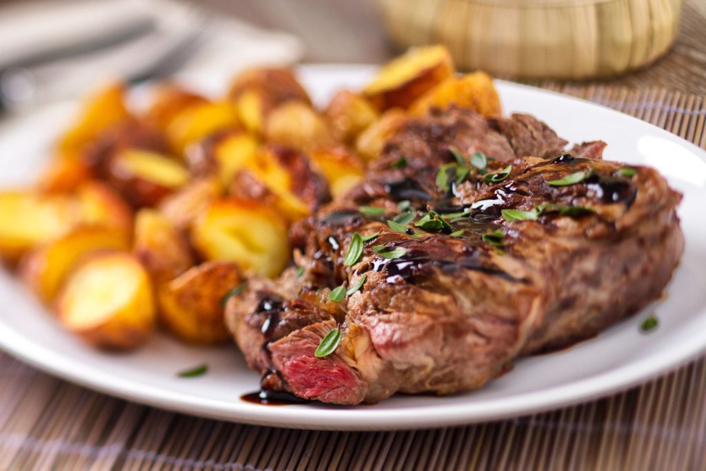 a plate with steak and roasted potatoes