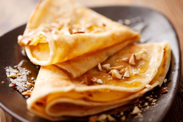A pair of cooked crepes and walnuts on them