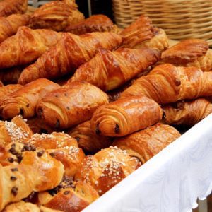 A lot of baked croissants on a white table cloth